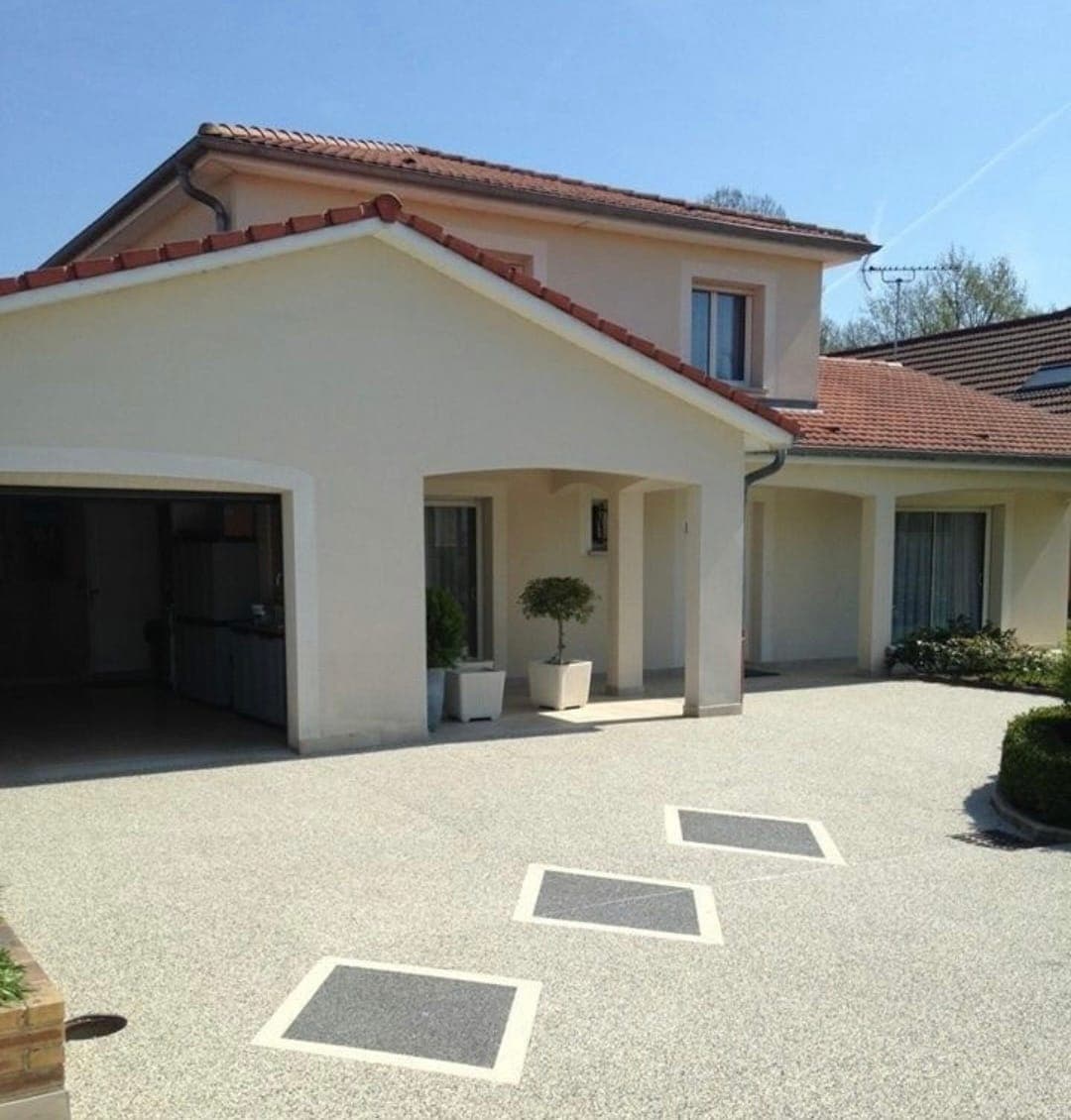 Cour de maison en béton désactivé avec inserts décoratifs, réalisée par Artisans de France