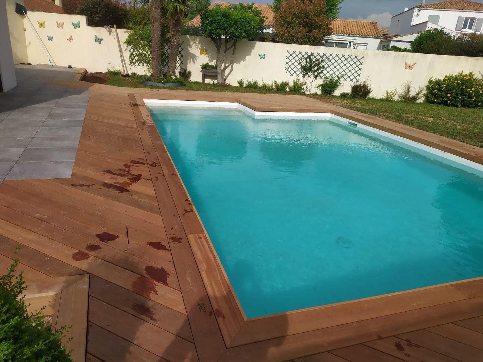 Piscine avec plage et terrasse en bois exotique, par Artisans de France