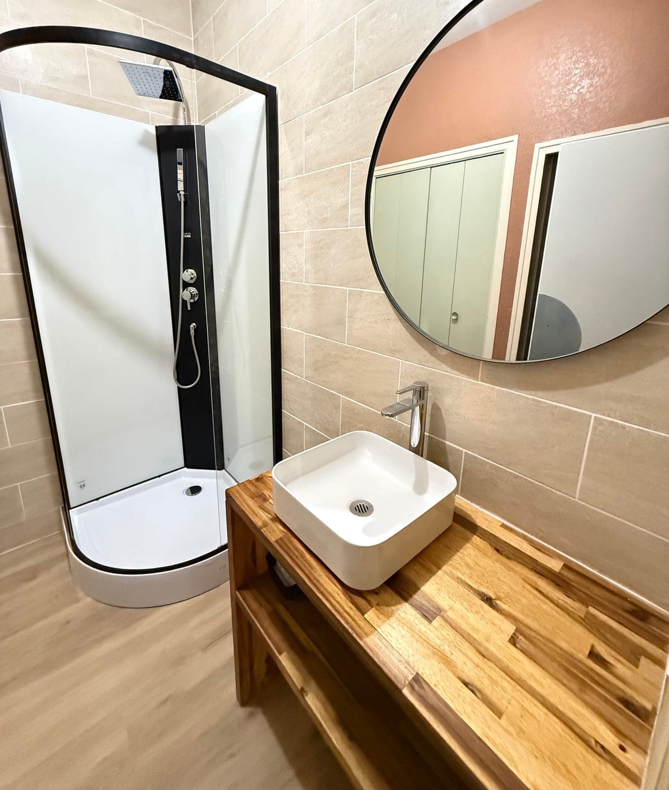 Salle de bain rénovée par Artisans de France : douche, vasque sur plan en bois et carrelage